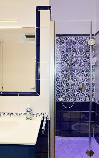 Bagno con doccia e rivestimenti blu in stile mediterraneo